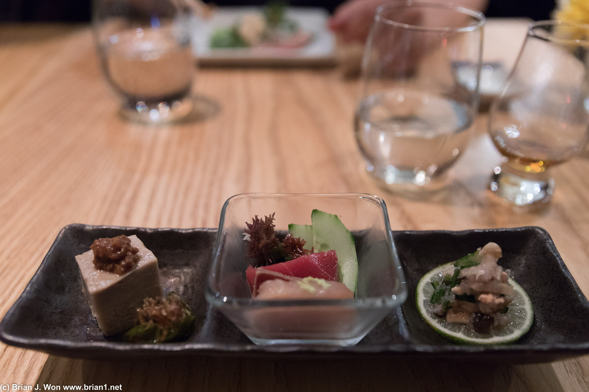 Omakase, first course: sesame tofu, albacore/bluefin/tuna, diced salmon and mushroom atop lime.
