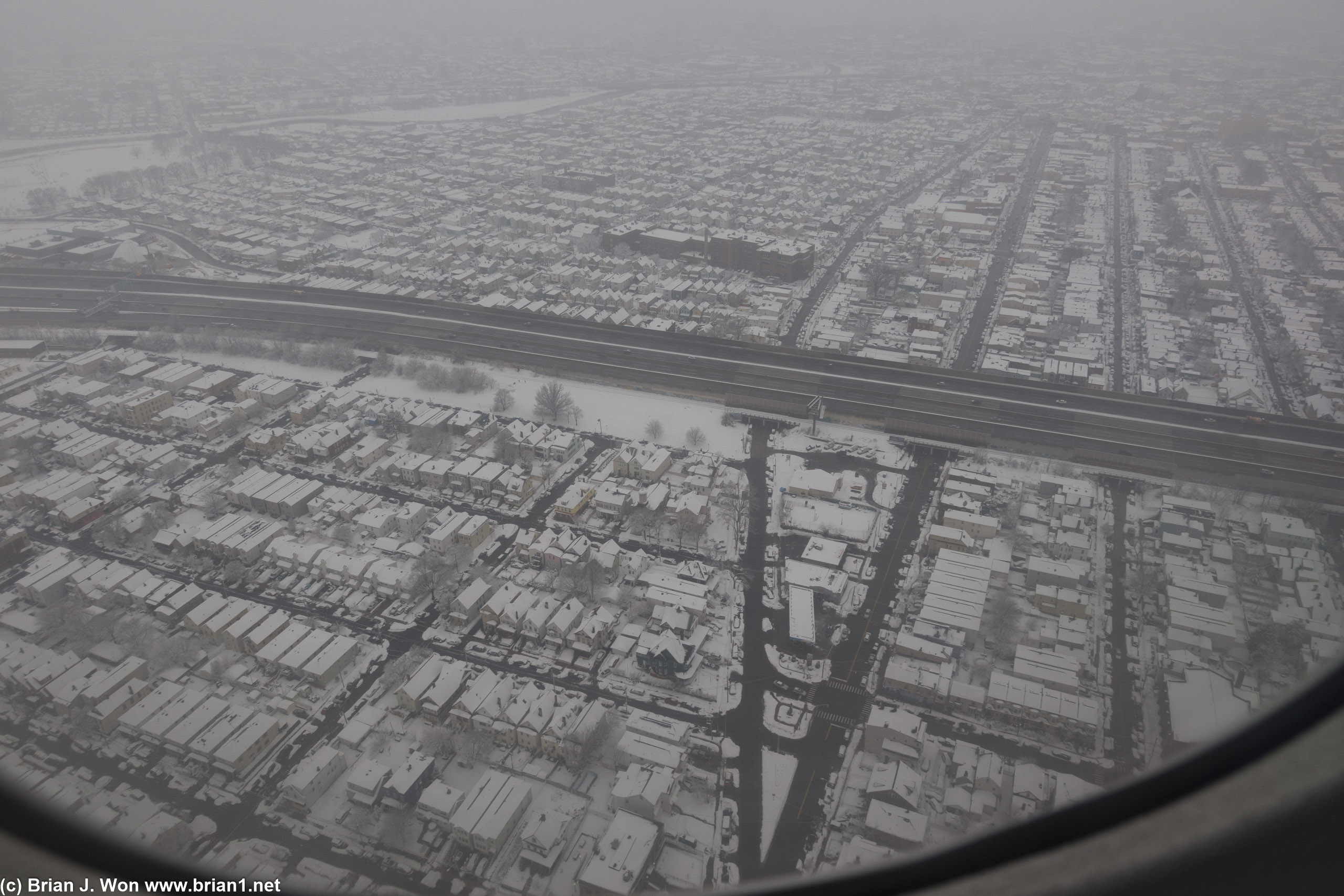 Snow-lined streets underneath final approach to Newark International Airport.