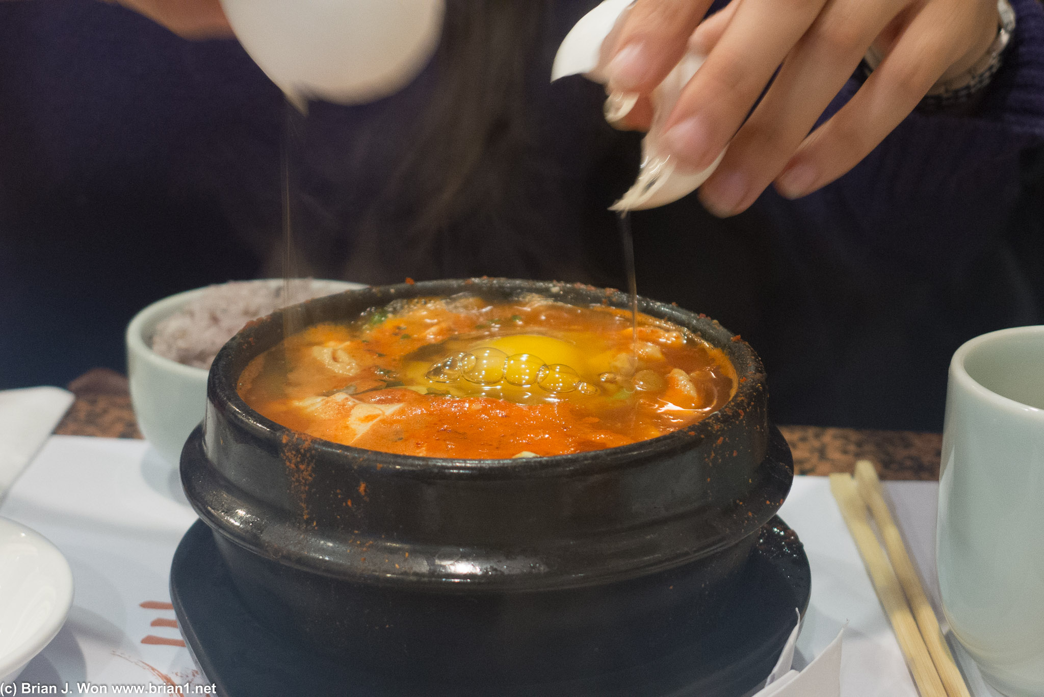 Petula cracks an egg into her soon tofu.