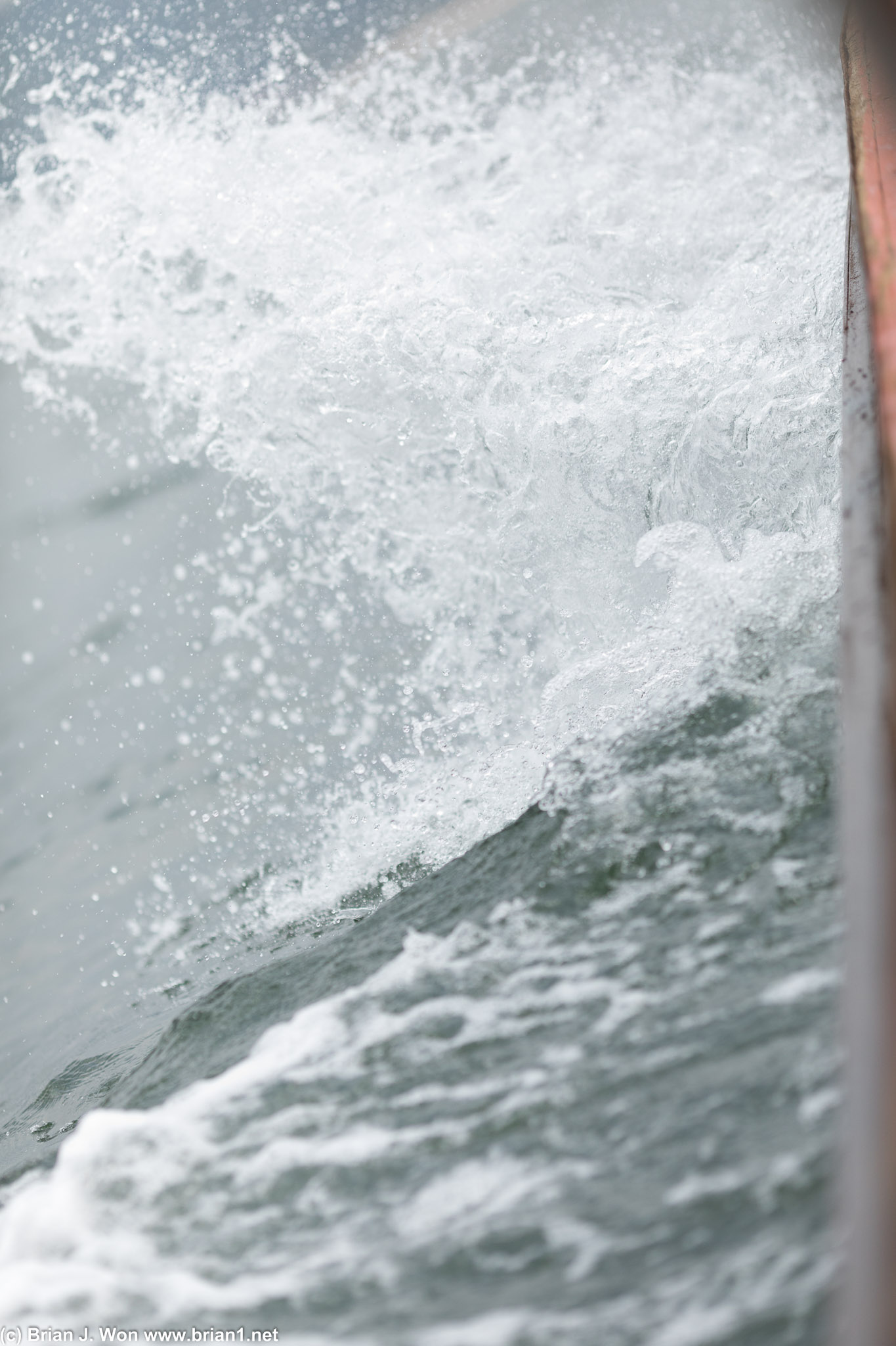 Water breaking over the bow of the longtail.
