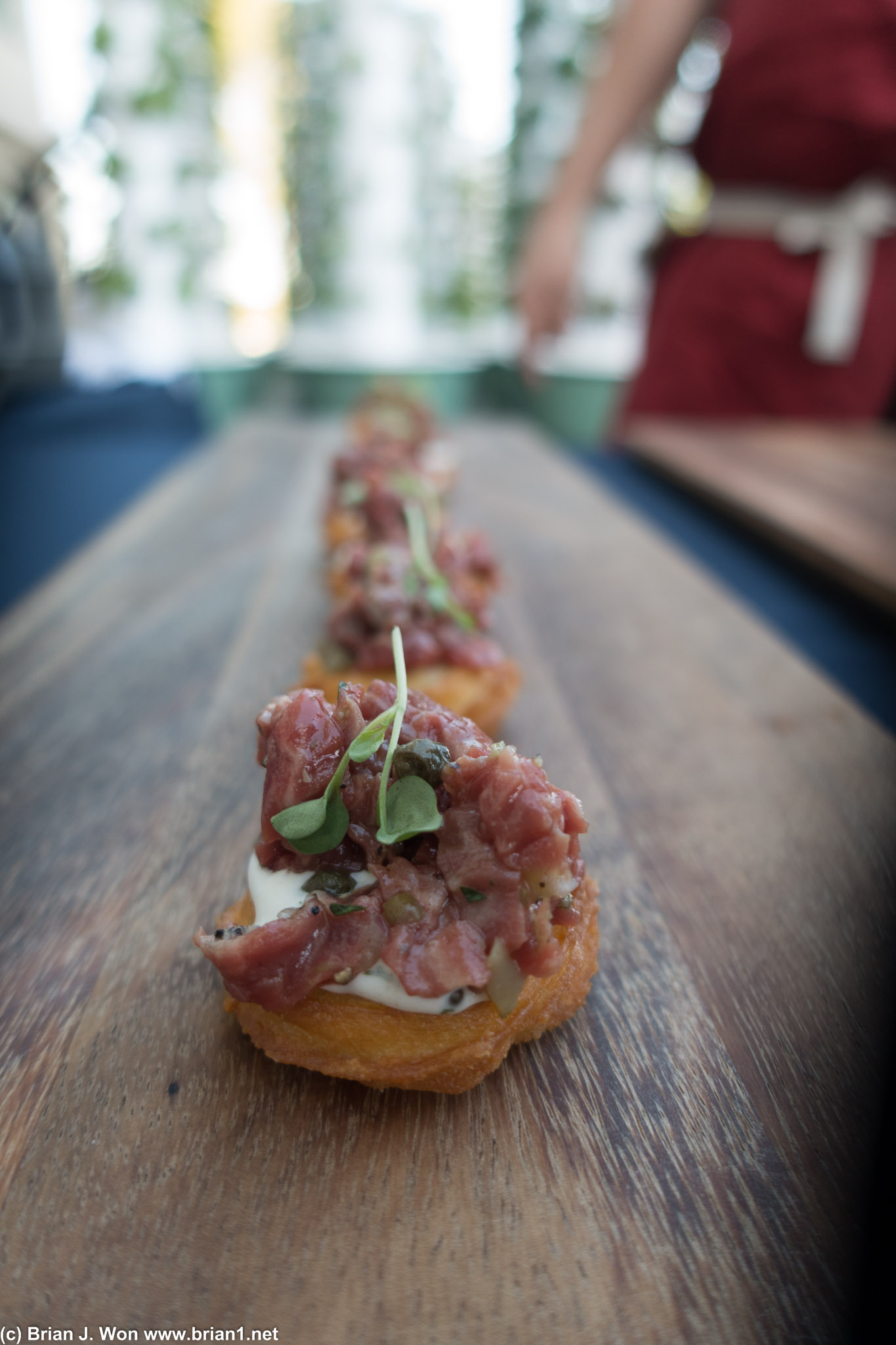 Beef tartare atop potato.