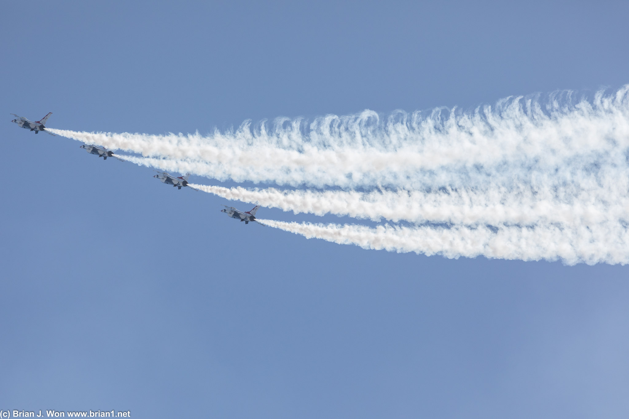 Stitching curls of smoke across the sky.