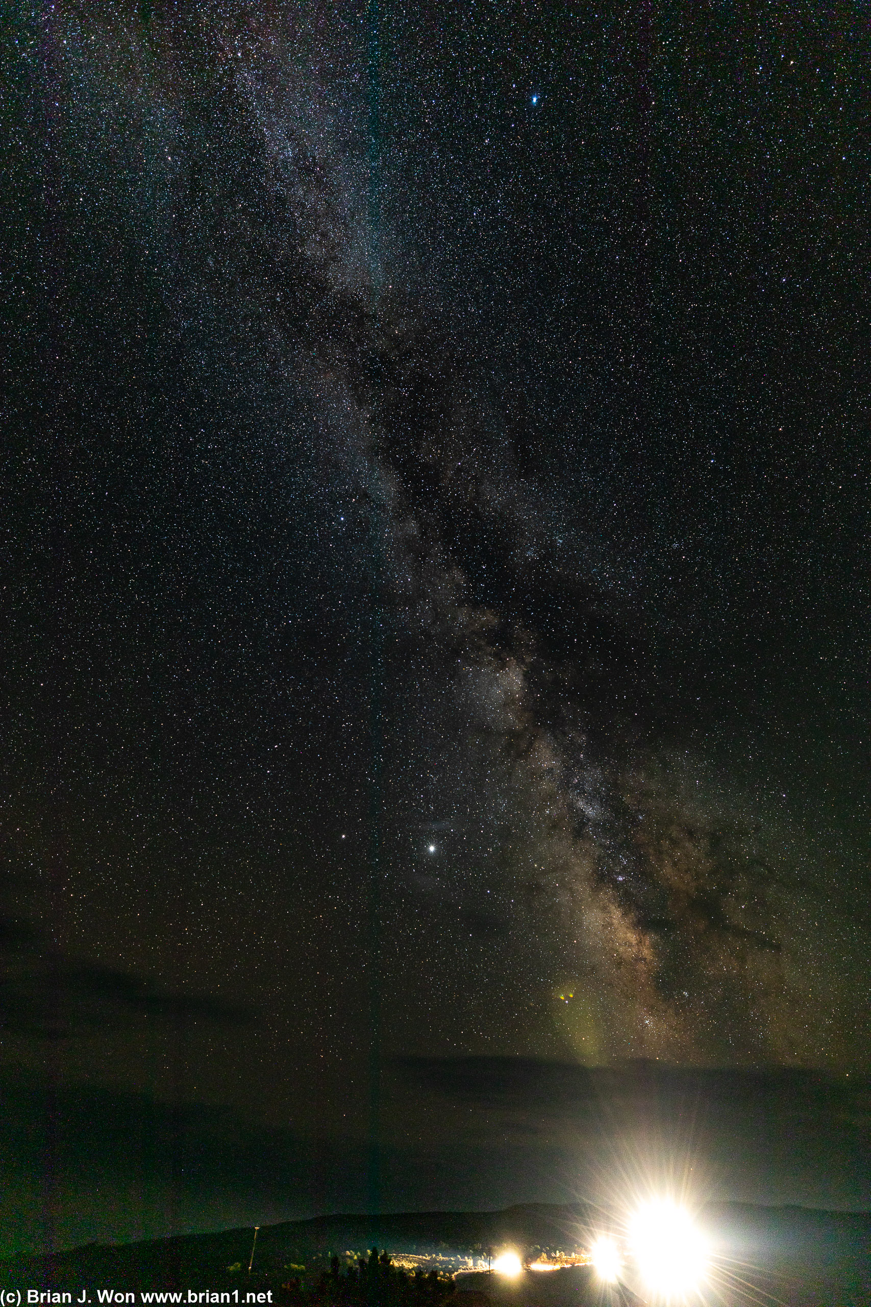 A row of passing cars competes with the night sky.