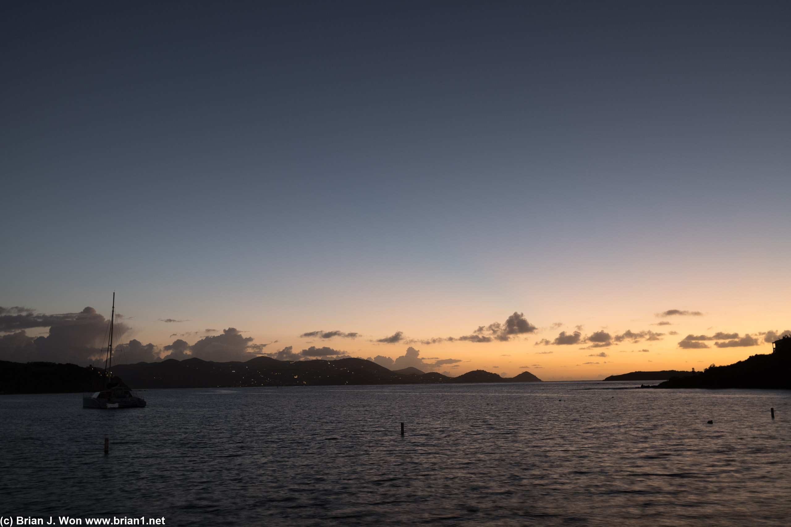 The sun's rays just begin to bathe the Ritz-Carlton's The Lady Lynsey II catamaran at anchor.