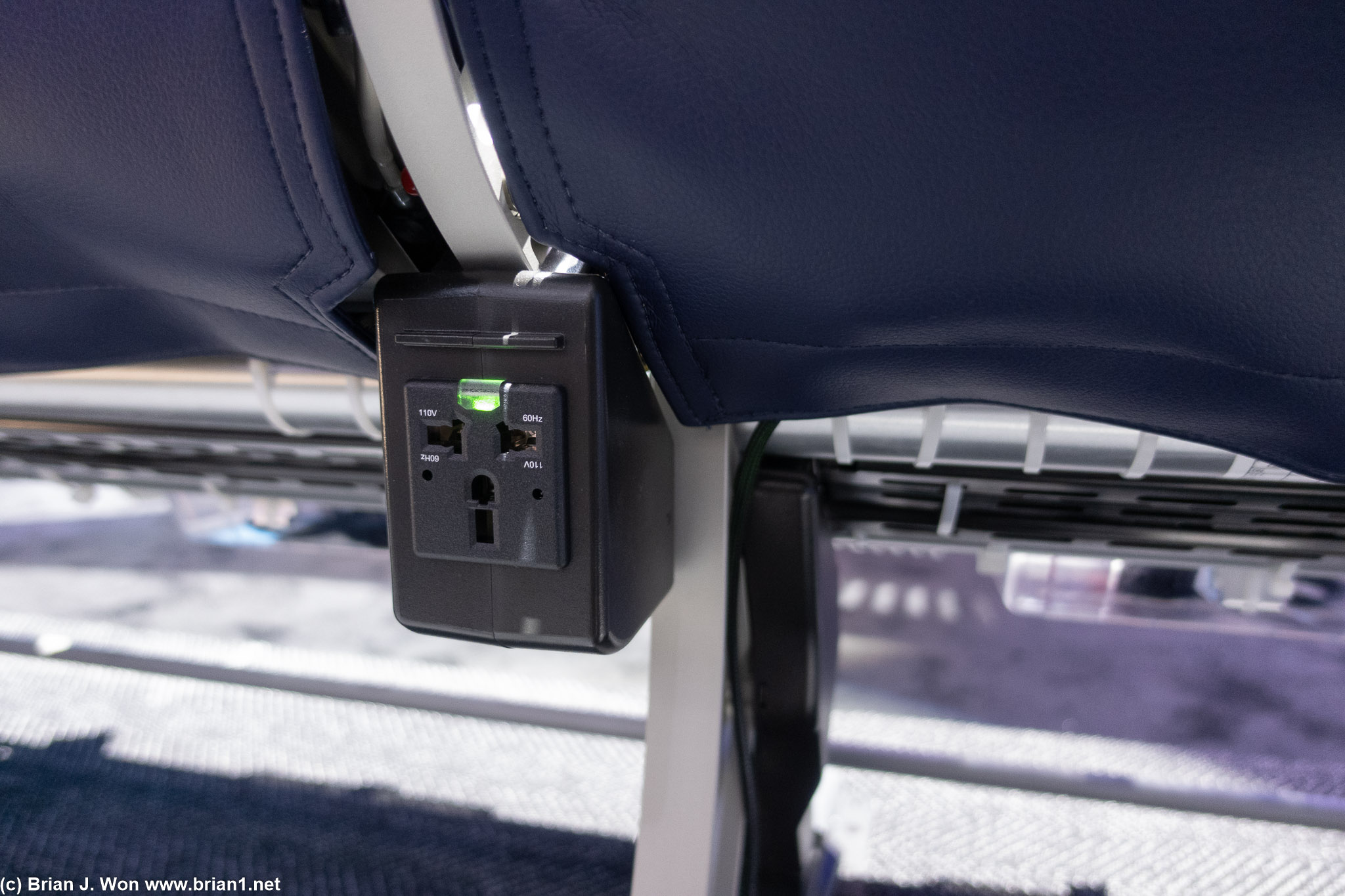 Two A/C outlets per triplet of seats. Not too annoying given the 65W USB-C at each seat.